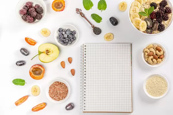 Empty notebook with healthy food ingredients, top view