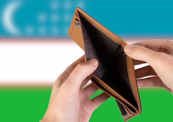 Empty Wallet with Flag of Uzbekistan. Recession and Financial Crisis to come with more debt and federal budget deficit?