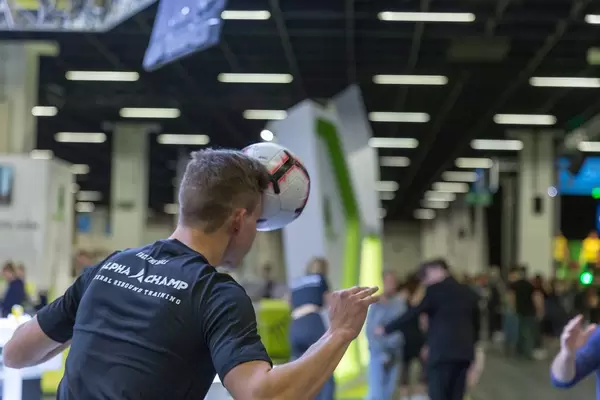 En Sportler von Alpha Champ Lateral Rebound Training träniert mit einem Fußball auf der Fitnessmesse in Köln