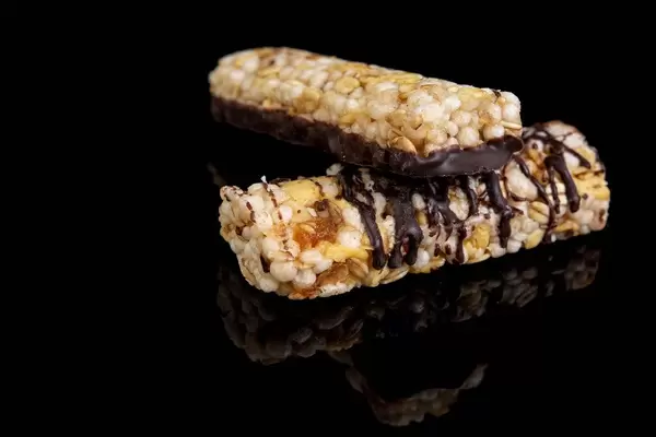 Energielieferant Müsliriegel mit Aprikose und Banane überzogen mit dunkler Schokolade, isoliert