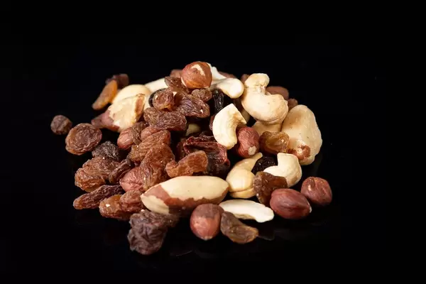 Energy mix with raisins hazelnuts cashew and brazilian nuts above black background (Flip 2019)