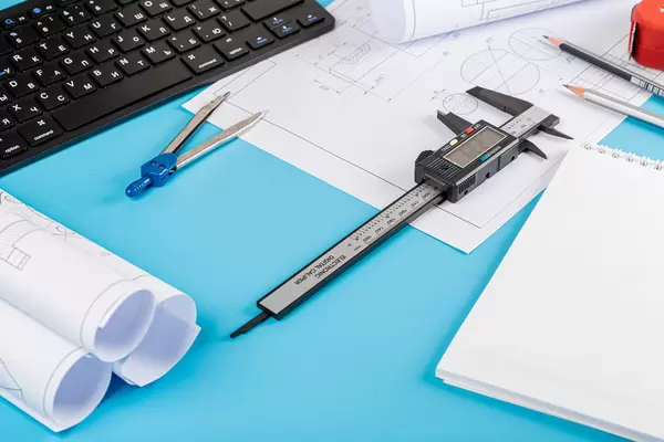 Engineer workplace concept with tools and drawings on blue background