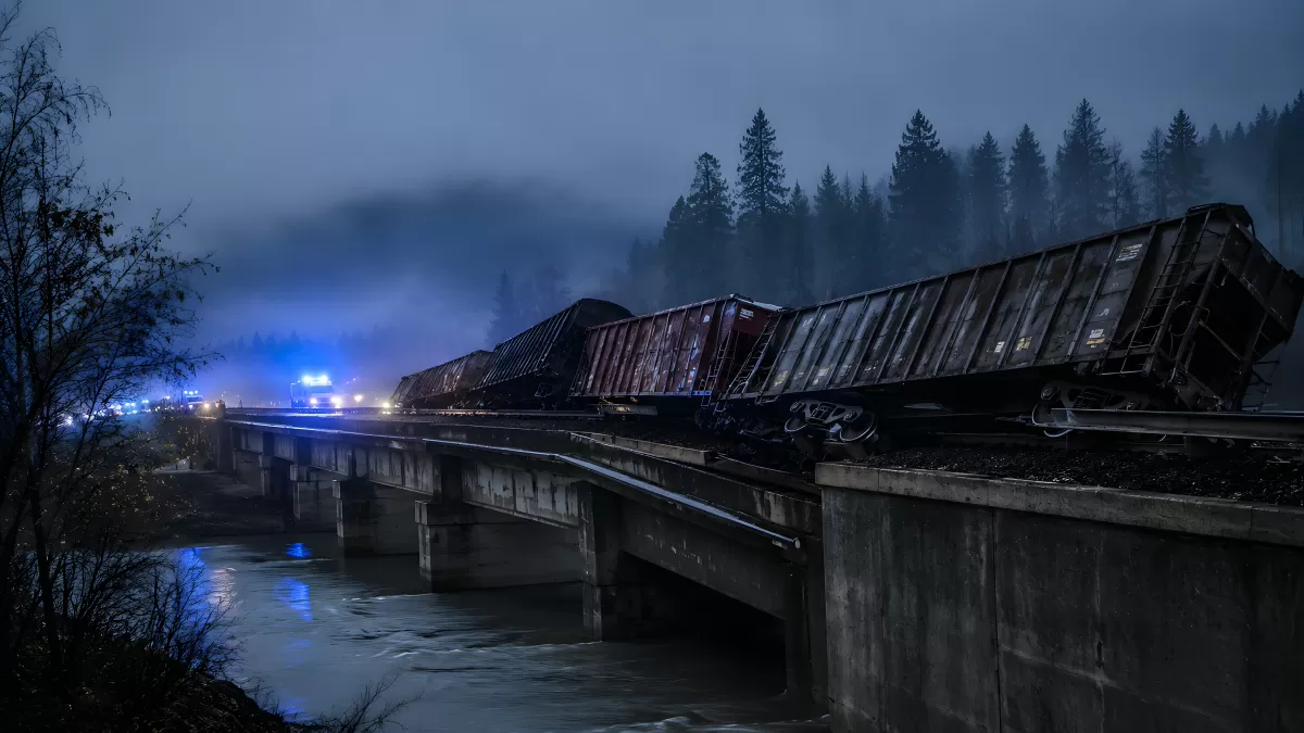 Entgleister Güterzug auf Brücke über Fluss bei Nacht