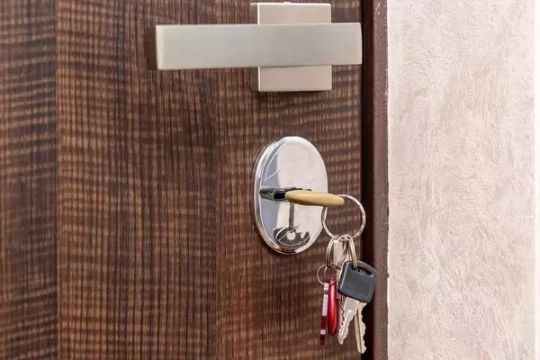 Entrance door with silver handle and keys in the keyhole