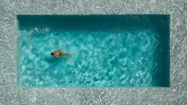 Entspannender Schwimmer in kristallklarem Pool