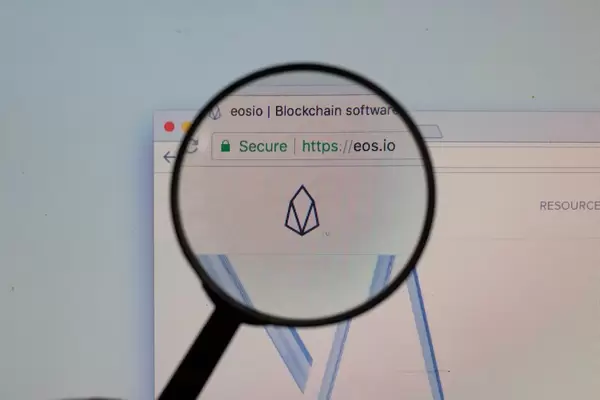 EOS-Logo am PC-Monitor, durch eine Lupe fotografiert