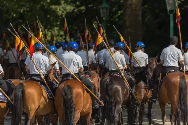 Equestrian police with Belgian flag on their side on a street of Brussels