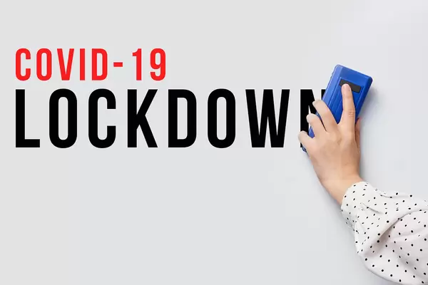 Erasing COVID-19 lockdown text from whiteboard - the symbol of the end of the quarantine