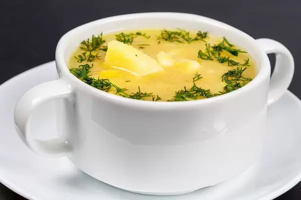 Erbsensuppe mit Dill und Kartoffeln in einer weißen Suppentasse Nahaufnahme