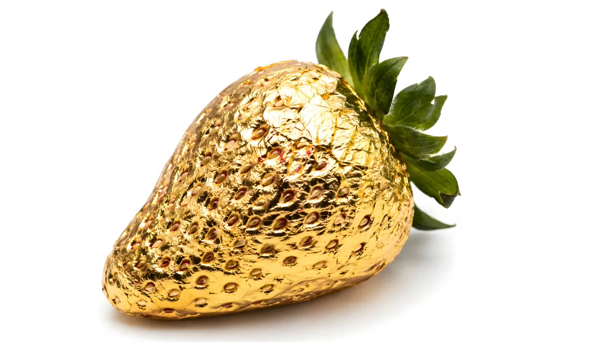 Erdbeere mit Blattgold überzogen auf weißem Hintergrund