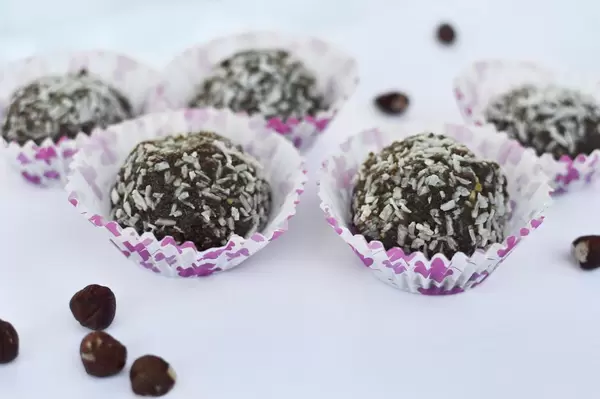 Erdnussbutterbällchen mit Kokosraspeln in Papierförmchen