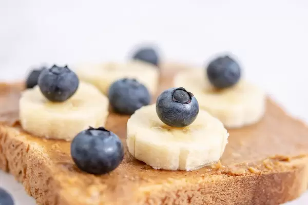 Erdnussbuttertoastbrot mit Heidelbeeren und Bananenscheiben in der Nahaufnahme