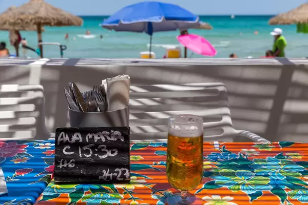 Erfrischung am Strand. Bier vom Fass, Reservierungsschild und Besteck auf dem Tisch