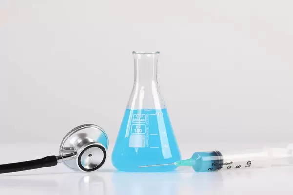 Erlenmeyer flask with syringe and stethoscope on white background
