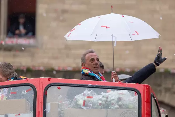 Erry Stoklosa der Kölschen Musikband "Bläck Fööss" mit weißem Regenschirm auf dem Deck des Wagens, mit dem die Band ihr 50-jähriges Jubiläum beim Kölner Karneval feiert