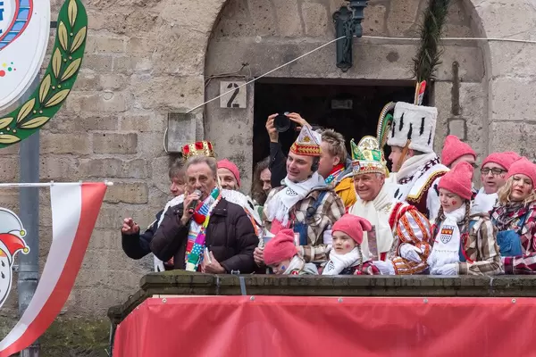 Erry Stoklosa von den Bläck Fööss (einer der erfolgreichsten Kölner Mundart-Musikbands) redet mit Mikrofon an der Severinstorburg beim Rosenmontagsumzug in Köln