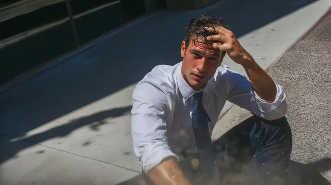 Erschöpfter Geschäftsmann im Anzug auf Stadtstraße