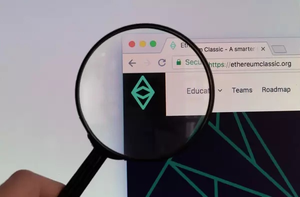 Ethereum Classic Logo am PC-Monitor, durch eine Lupe fotografiert