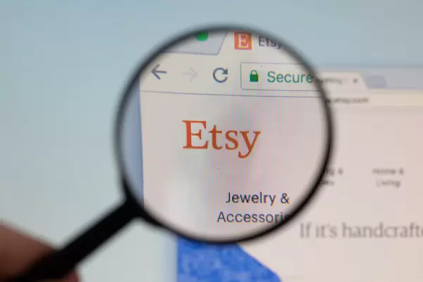 Etsy-Logo am PC-Monitor, durch eine Lupe fotografiert