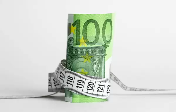 Euro banknote with measure tape on white background