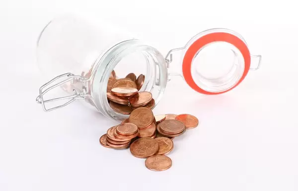 Euro cent coins spilling out of a jar on white background