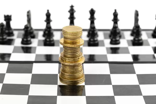 Euro coins stacked like a king on a chess board