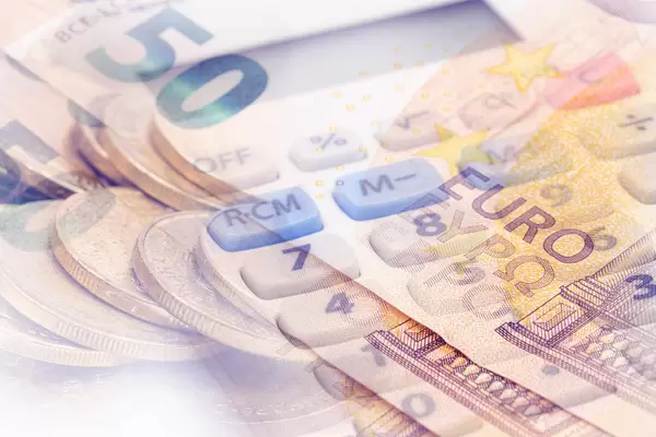 Euro currency in paper and coins with calculator in the background