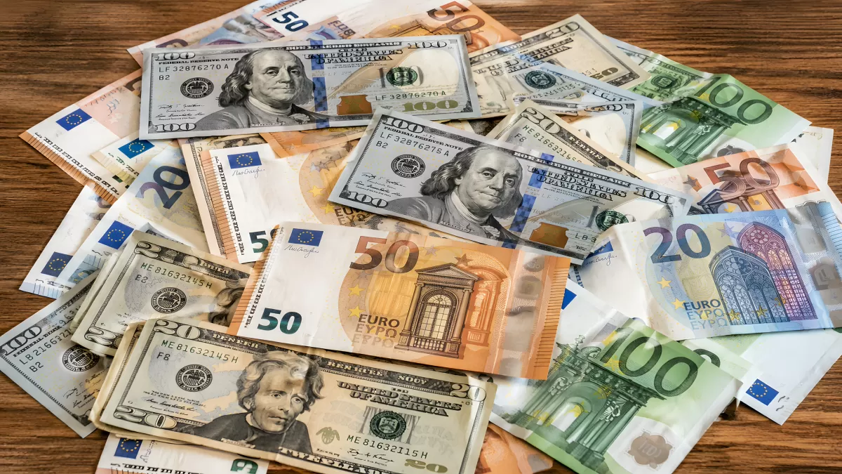 Euro- und Dollarscheine verstreut auf Holztisch