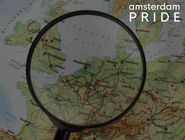 Europe under magnifying glasses with the marked destination Amsterdam on a map, next to the title Amsterdam Pride, an annual weekend long festival