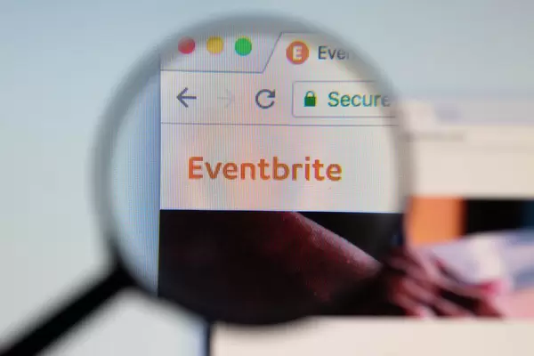Eventbrite-Logo am PC-Monitor, durch eine Lupe fotografiert
