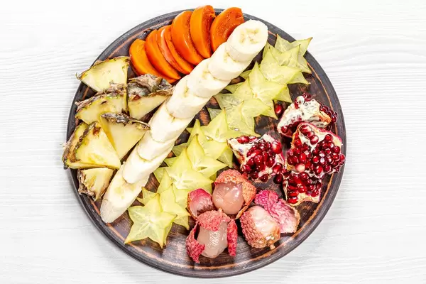 Exotic ripe fruit slices on a plate. The view from the top