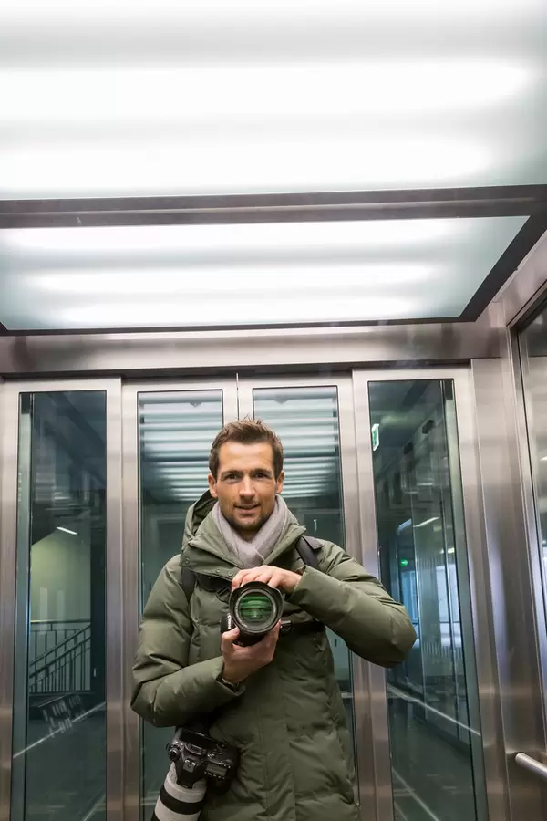 Exploring the new BER airport as a photographer with two professional cameras: self-portrait in the lift