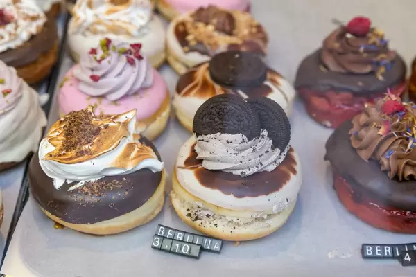 Extravagante "Berlina" Donuts mit Orio-Keks-Topping, Schokolade und Blütenblättern aus der veganen Bäckerei chök in Barcelona, Spanien