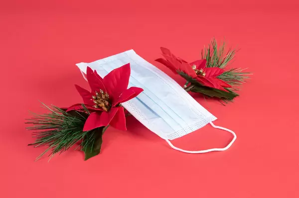 Face mask and Christmas decorations on red blue background