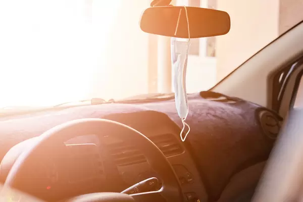 Face mask hanged on the rear-view mirror in the car