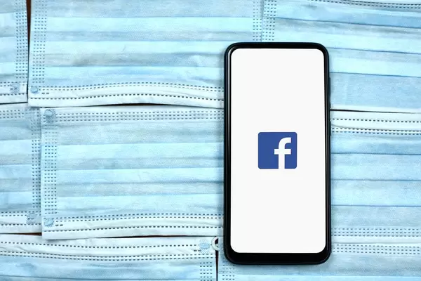 Facebook logo on phone. Impact of covid-19 crisis on Facebook business