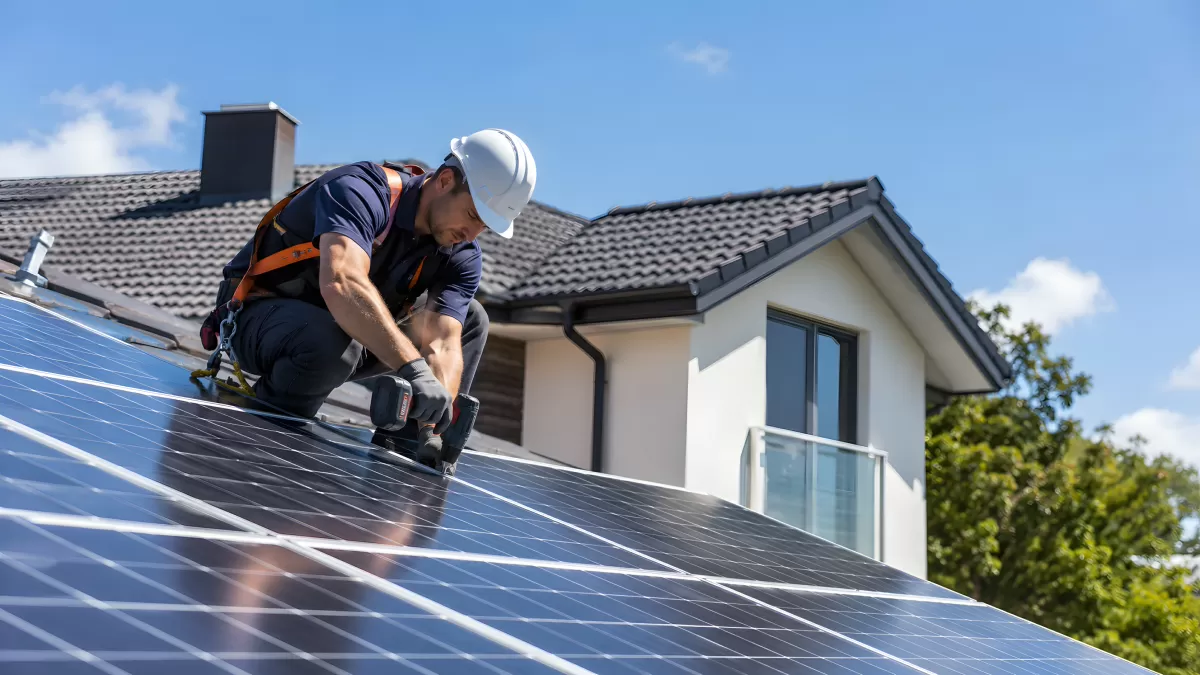 Fachmann montiert Solarmodule auf dem Hausdach