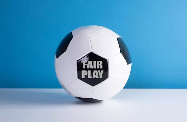 Fair Play text on a soccer ball with blue background