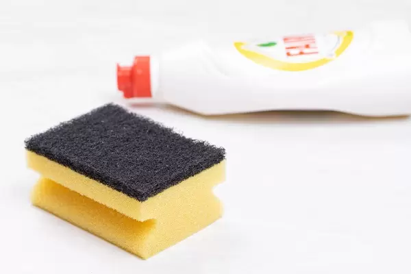Fairy detergent bottle with Dish Sponge on the table