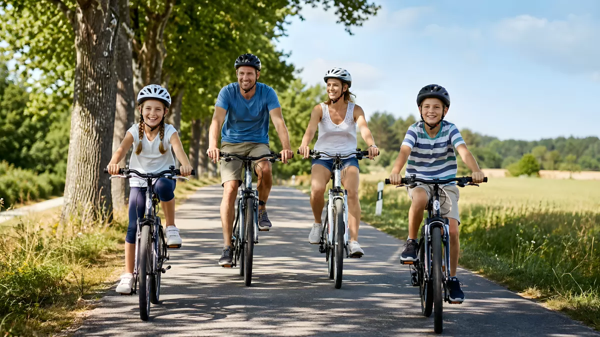 Familie fährt gemeinsam Fahrrad auf Landstraße