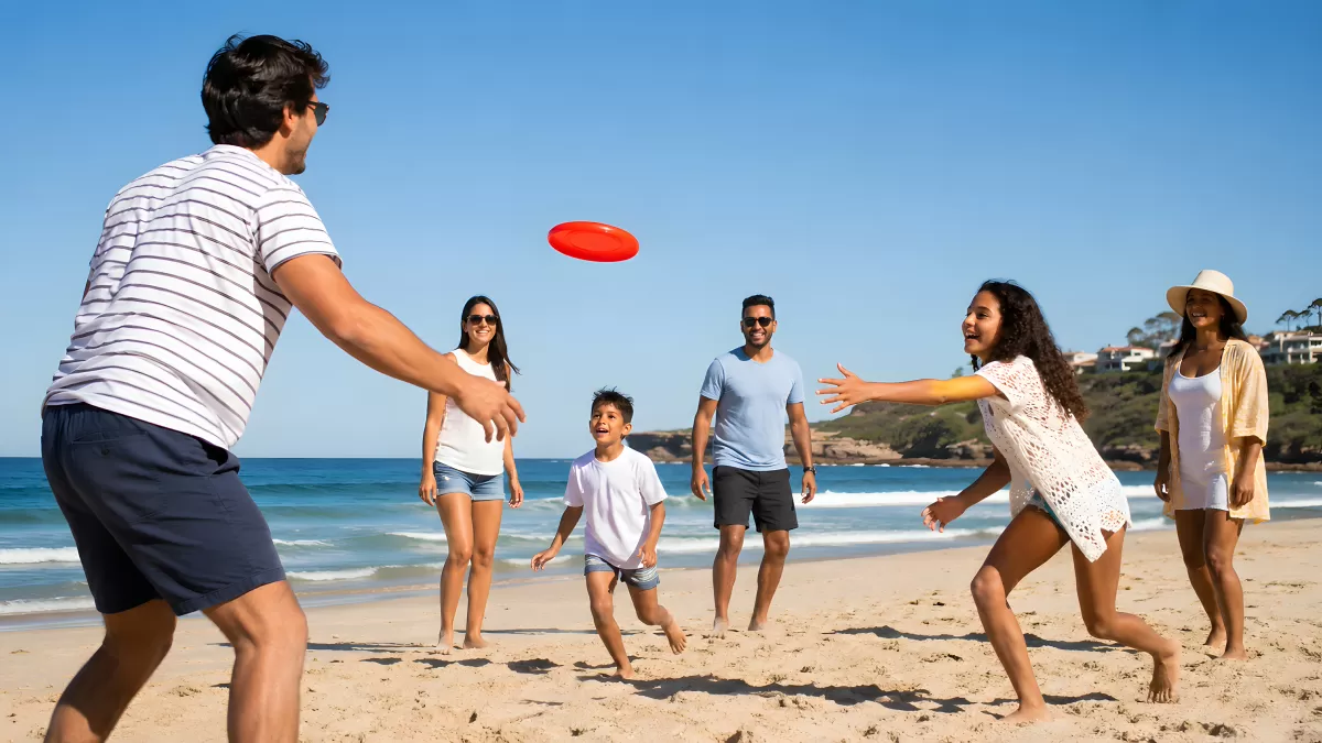Familie spielt Frisbee am sonnigen Sandstrand