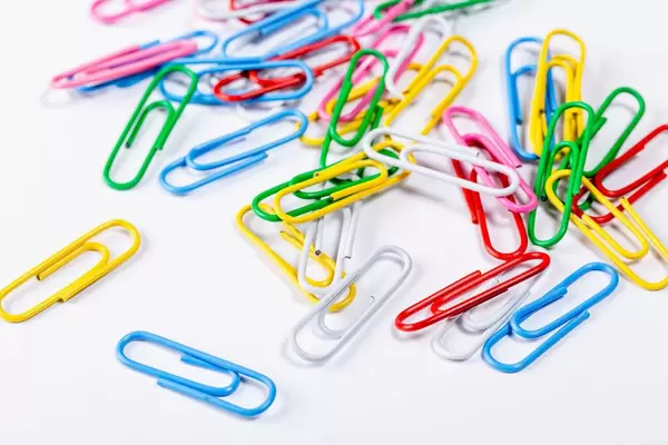 Farbenfrohe Büroklammern auf weißem Tisch