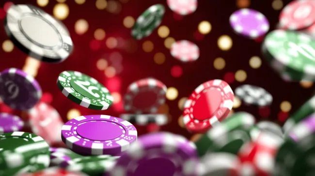Farbenfrohe Casino-Chips vor glitzerndem Hintergrund