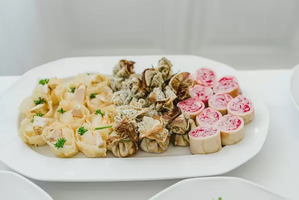 Farbenfrohe, gerollte Häppchen als Vorspeise auf einem weißen Teller