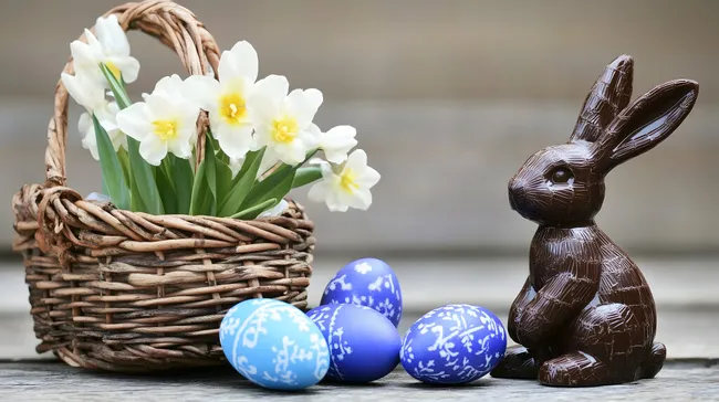 Farbenfroher Osterkorb mit Narzissen und Schokoladenhasen