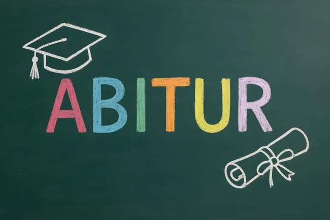 Farbenfroher Schriftzug 'Abitur' mit Doktorhut und Diplom