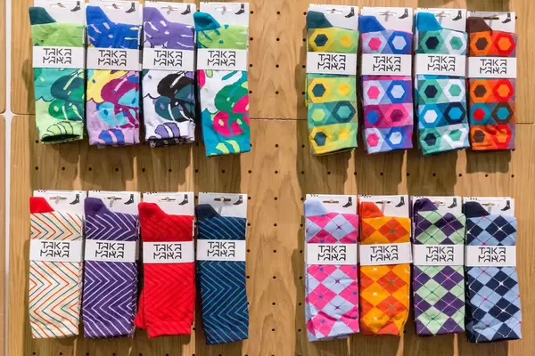 Farbige, unterschiedlich gemusterte und auffällige Socken von Takapara zum Verkauf an Holzwand