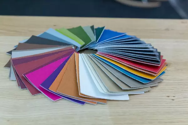 Farbmuster aus Stoff liegen in Kreis auf Holztisch