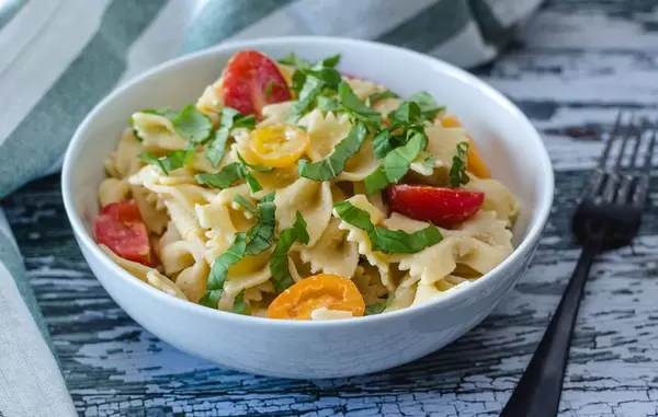 Farfalle-Nudelteller mit frischem Basilikum und Tomaten