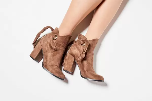 Fashion model with beautiful legs wearing high heel shoes on white background